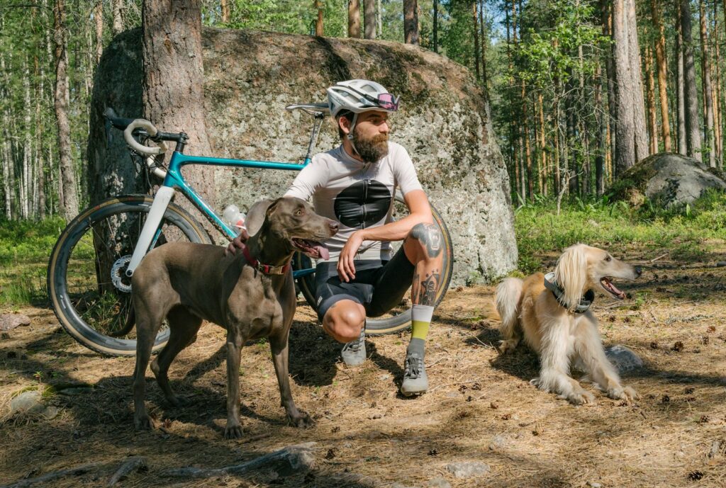 Hund läuft auf einem Parkweg neben einem Radfahrer, ein Risiko, das die Hundehaftpflicht absichert