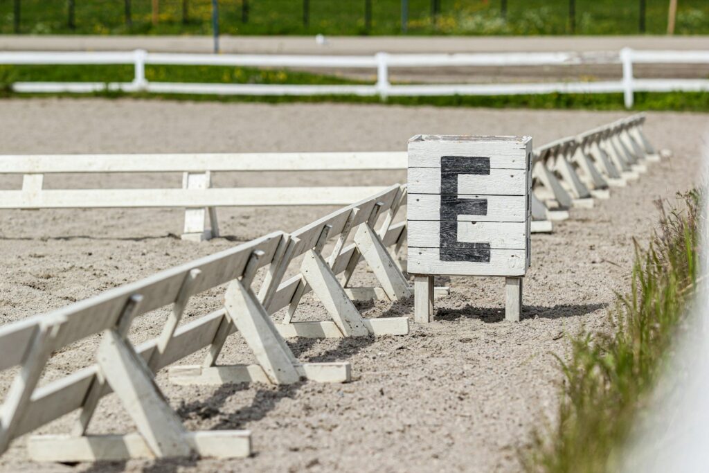 Bahnfiguren reiten: Buchstaben an der Bande eines Dressurvierecks